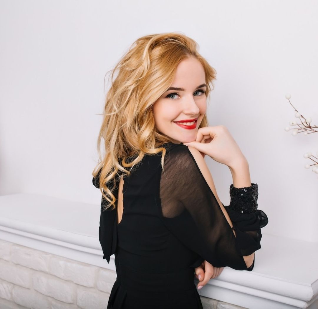 side view closeup portrait girl with blonde wavy hair white modern room with floor lamp fireplace lady smiling posing wearing stylish black dress 197531 2848 8c54688b Blonde Specialist Delray Beach
